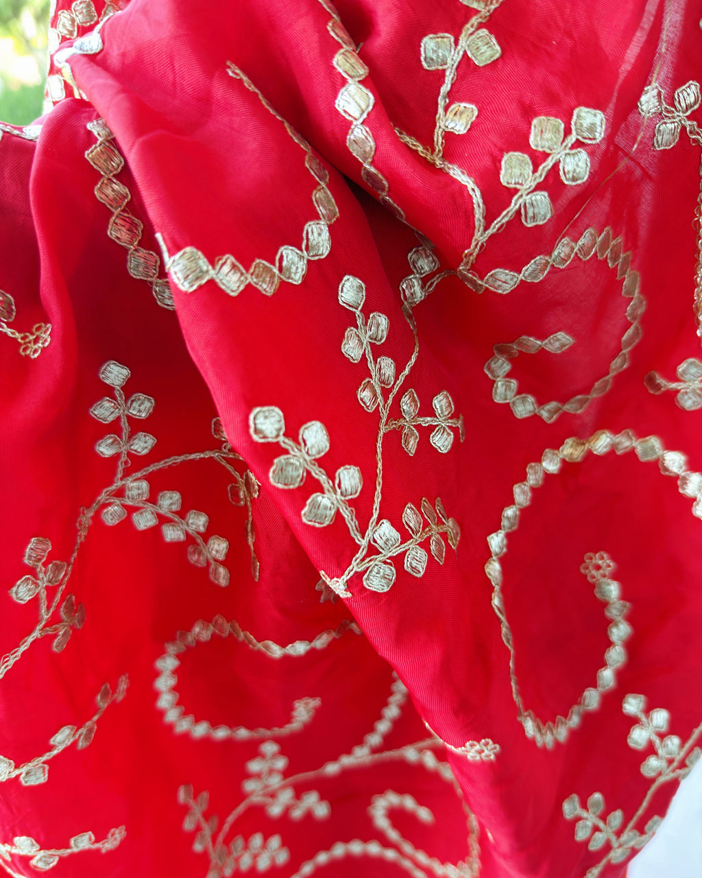 Close-up of embellished Gotta Patti border on red saree