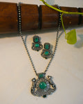 Sher-e-Hara antique oxidised silver lion pendant necklace and stud earrings set with green onyx stones displayed on a white fabric surface