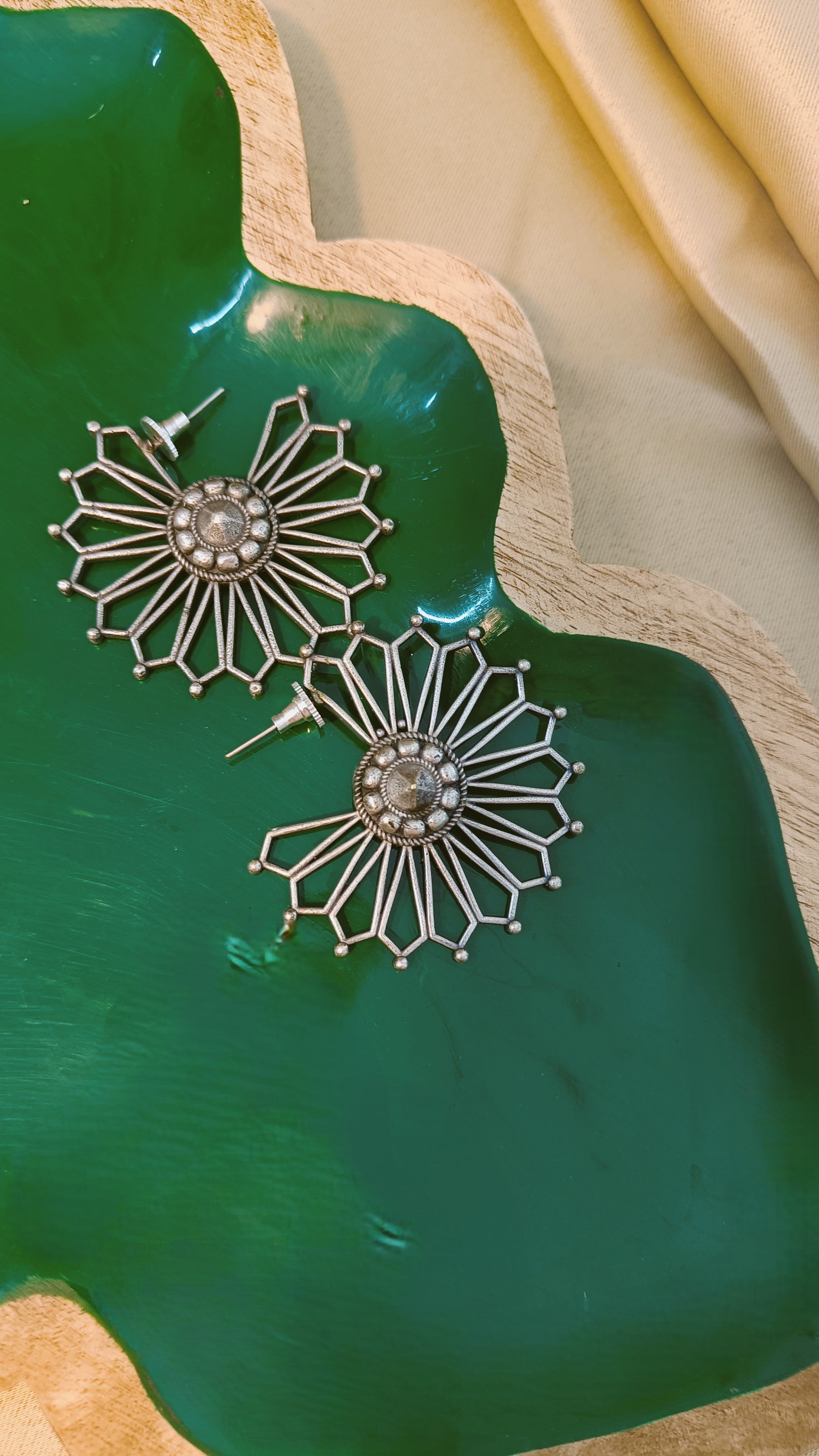 Surya Chakra antique oxidised silver sunburst stud earrings placed in a soft jewellery pouch, ready for gifting