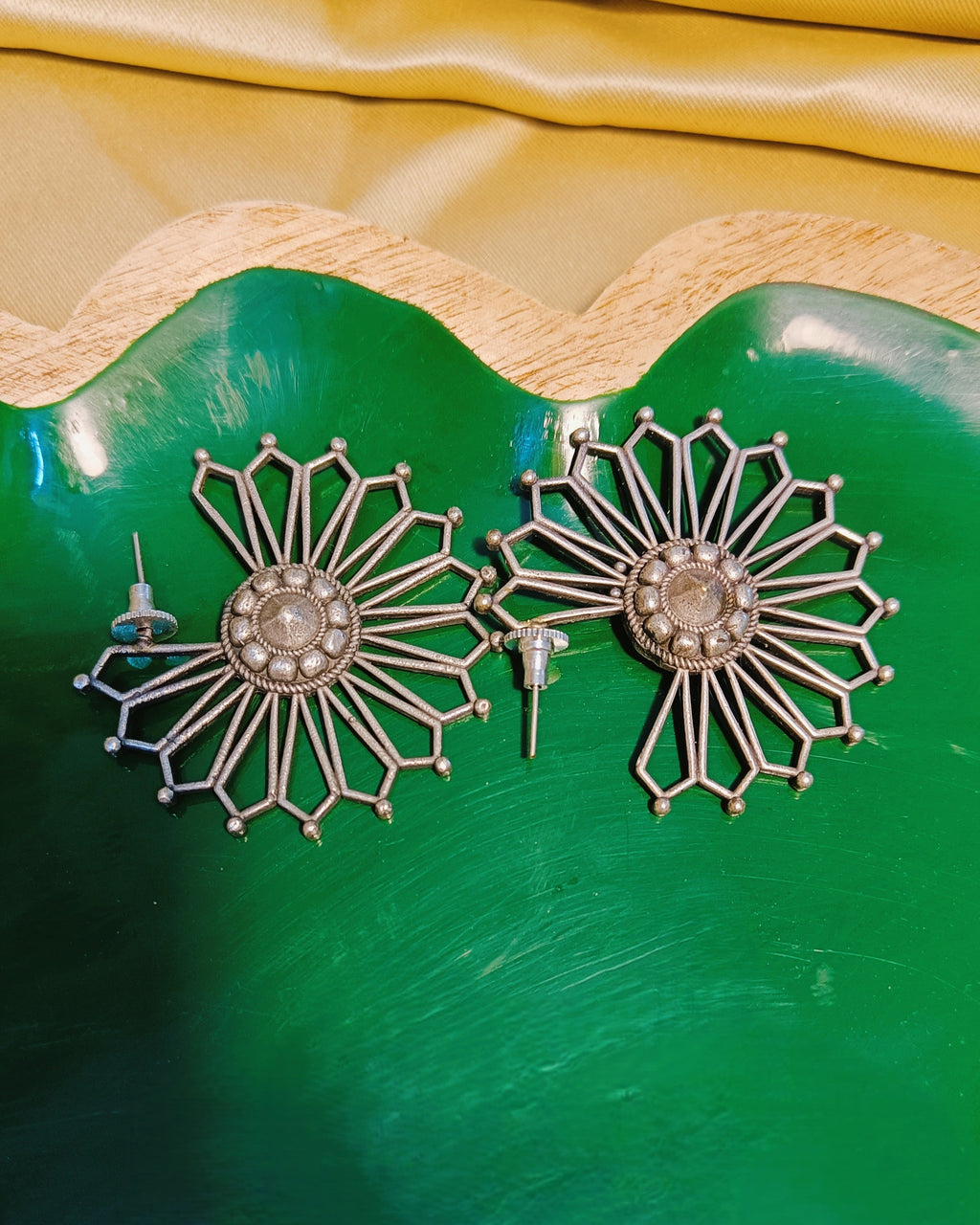 Surya Chakra antique oxidised silver sunburst stud earrings styled with ethnic wear showcasing the open-work geometric mandala disc design