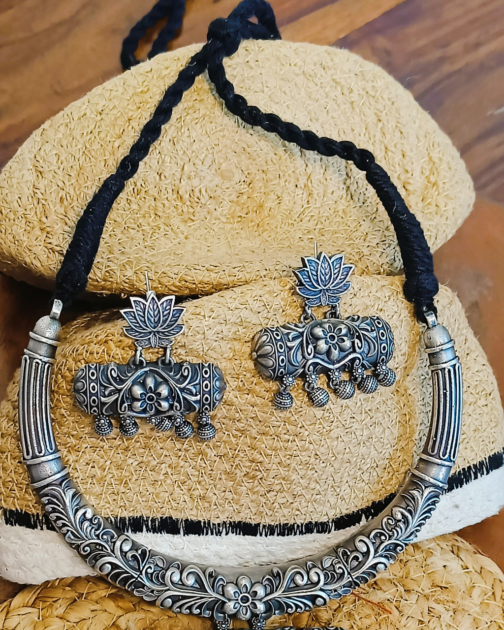 Detailed view of the three-tiered carved rectangular pendant with floral geometric panels and delicate ghungroo drops in antique oxidised silver