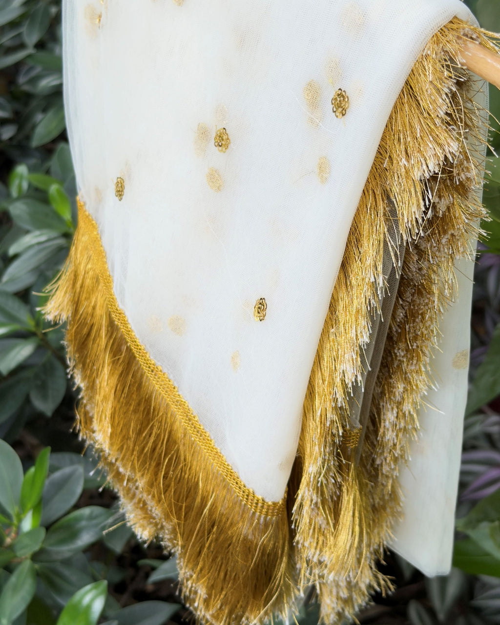 Close-up of golden floral motifs on white net dupatta