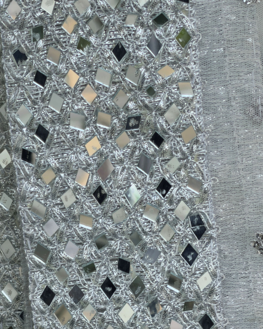 Close-up of mirror work border on white silver net dupatta