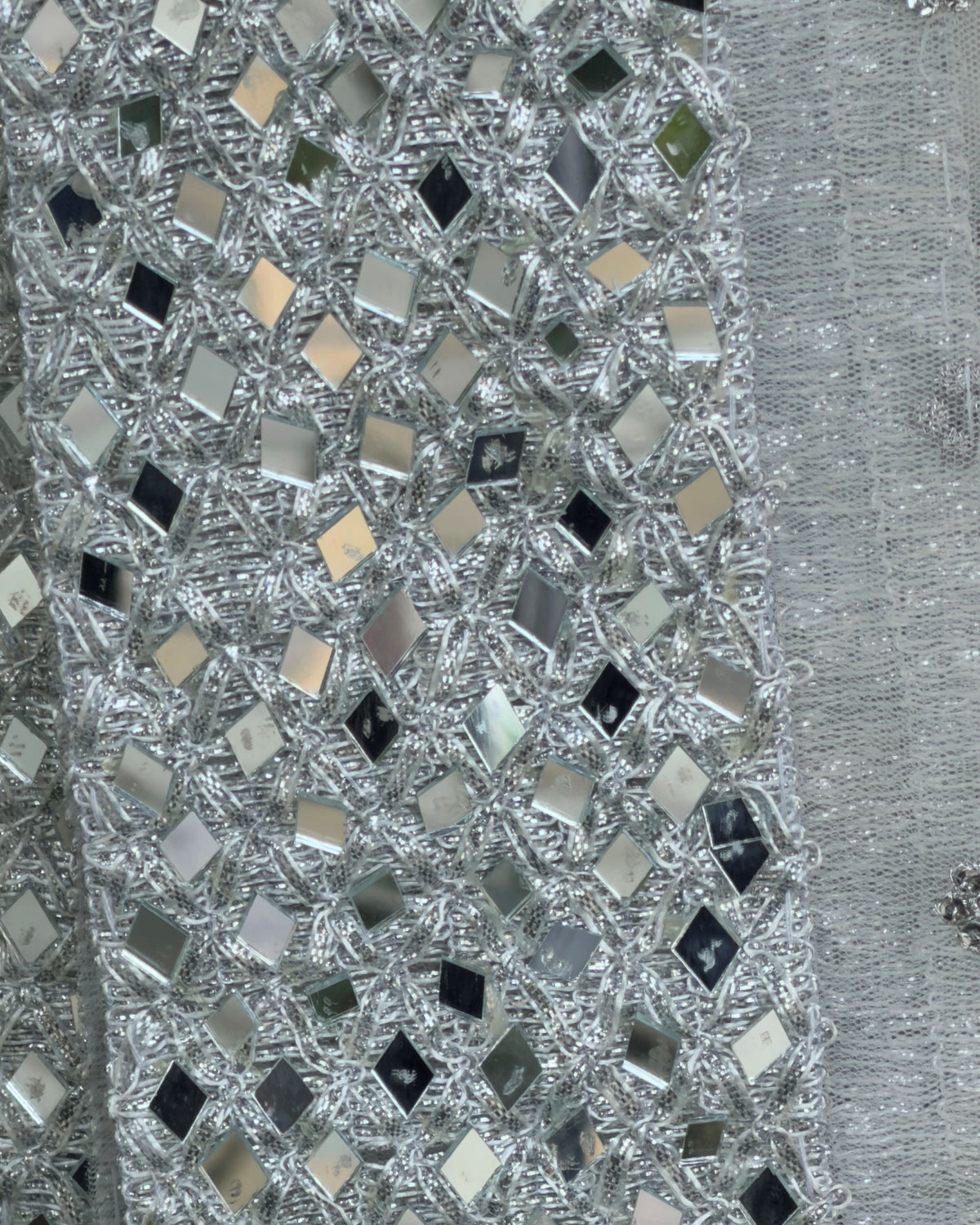 Close-up of mirror work border on white silver net dupatta